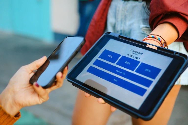 A woman uses digital tablet to pay and tip a barista in Santa Monica, California.
