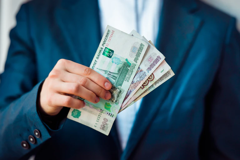 A businessman holding several rouble notes.
