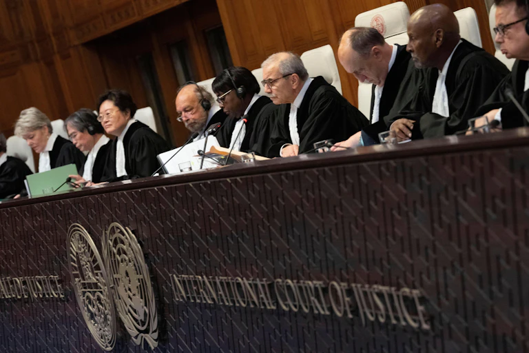 Judges sit in a row behind desk