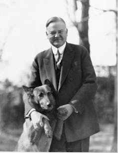 A black and white photo shows a man with a dog.