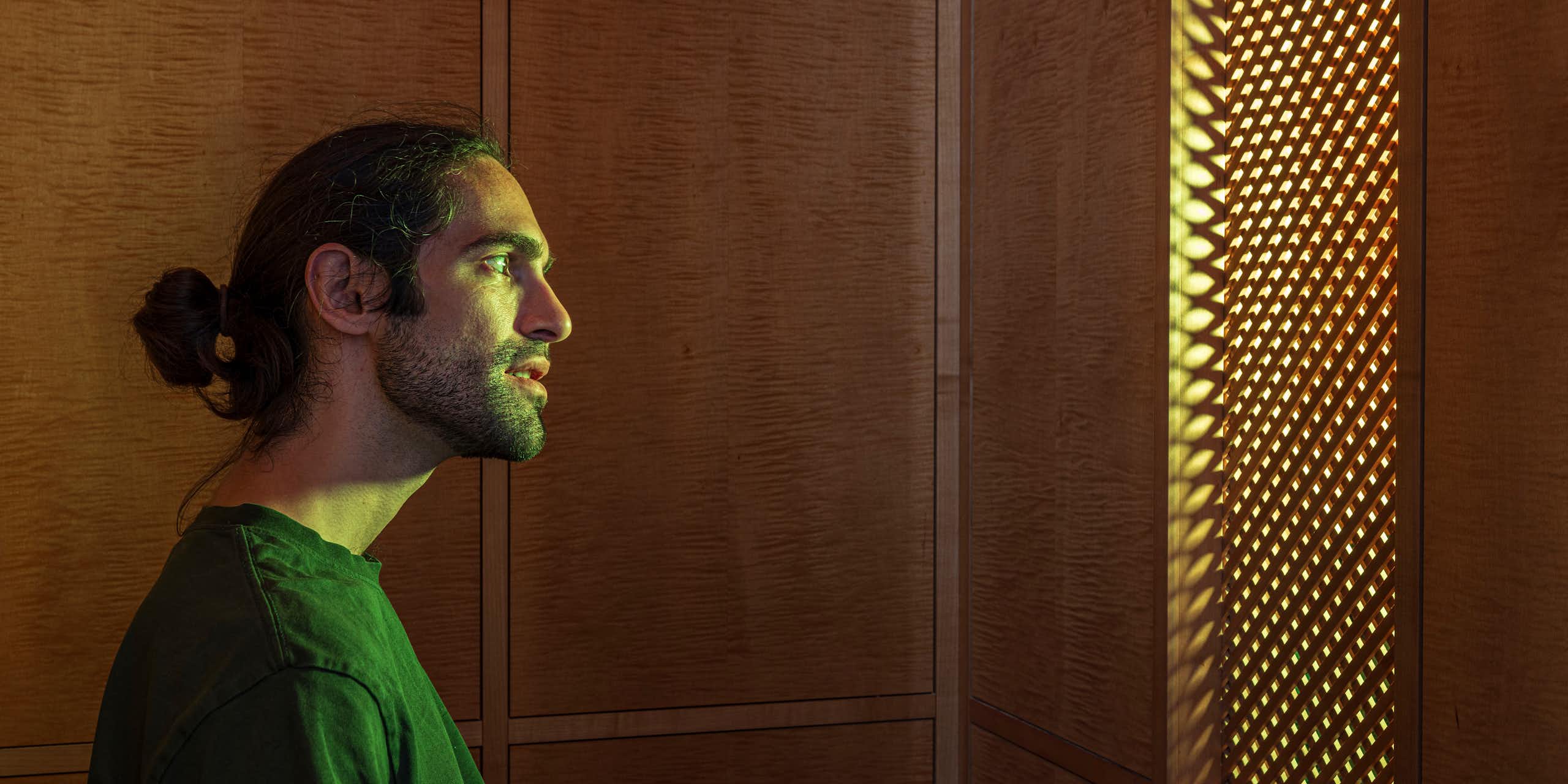 A hologram of an AI Jesus behind a latticework screen.