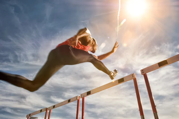 Athlete jumping over a hurdle.