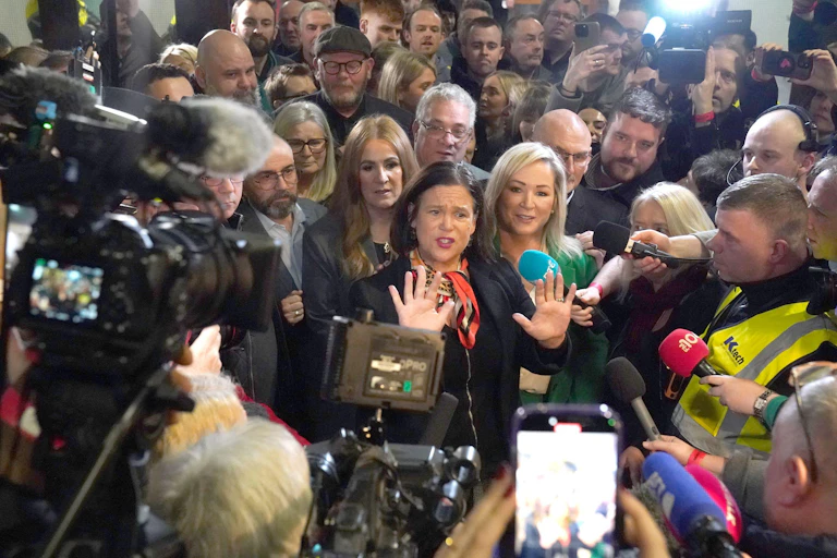 Mary Lou Mcdonald and Michelle O'Neill at the centre of a crowd of reporters.