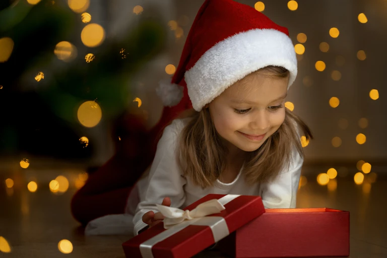 Une petite fille avec un bonnet de Père Noël.