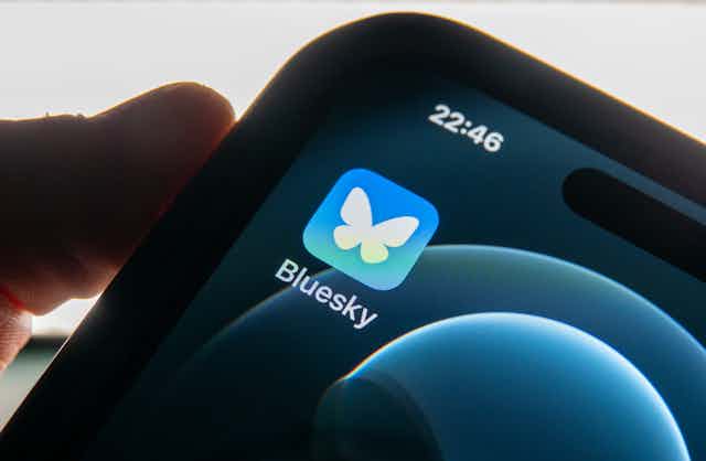 close-up of a smartphone screen with one icon and a person's thumb on the edge of the phone