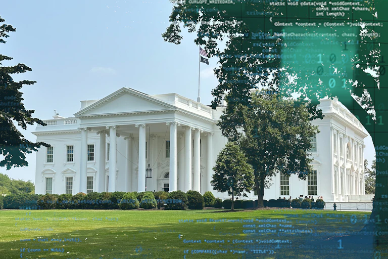 A large white, columned mansion surrounded by a lawn.