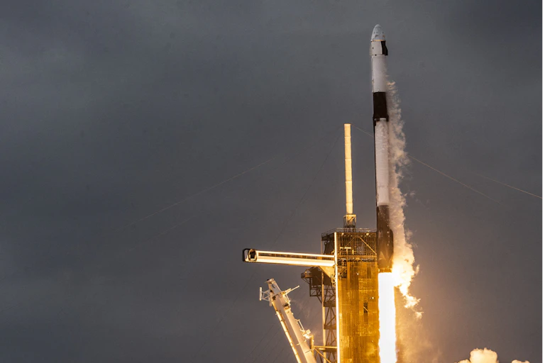 A rocket blasts off at a nighttime launch.