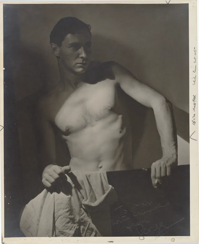 A shirtless man in the shadows.
