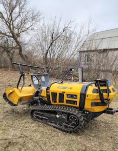 A small,yellow, armored bulldozer.