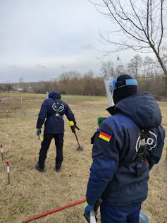 Deux hommes avec un uniforme bleu.
