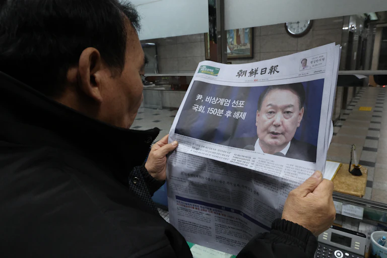 A South Korean man reads a newspaper with a picture of President Yoon Suk Yeol on the front page.