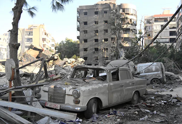 A destroyed car is seem among rubble.