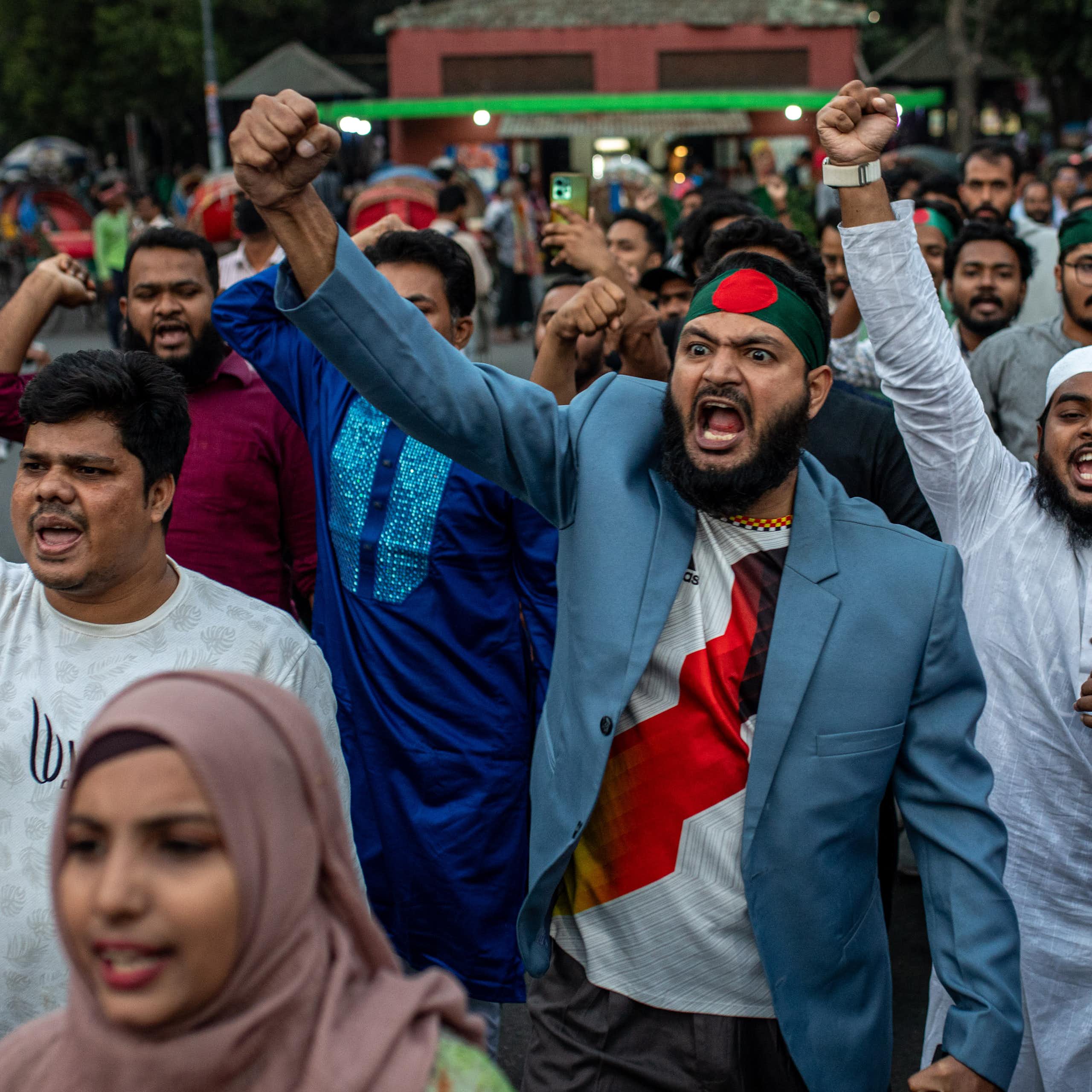 Men with raised fists march down a street.