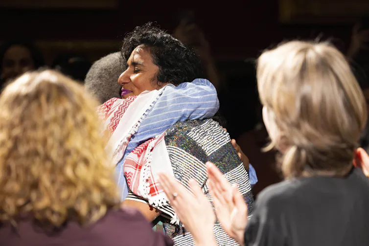 Two woman hugging in a crowd at the Turner Prize ceremony.
