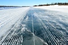 An icy surface is seen under a clear sky.