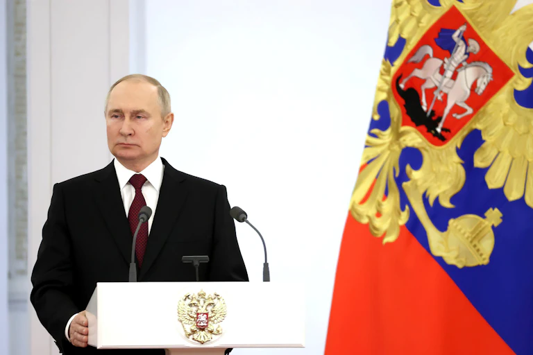 President Putin at a podium next to a Russian flag.