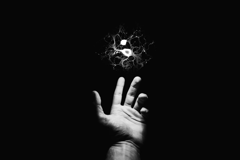 Illustration of outstretched hand reaching for a floating neuron