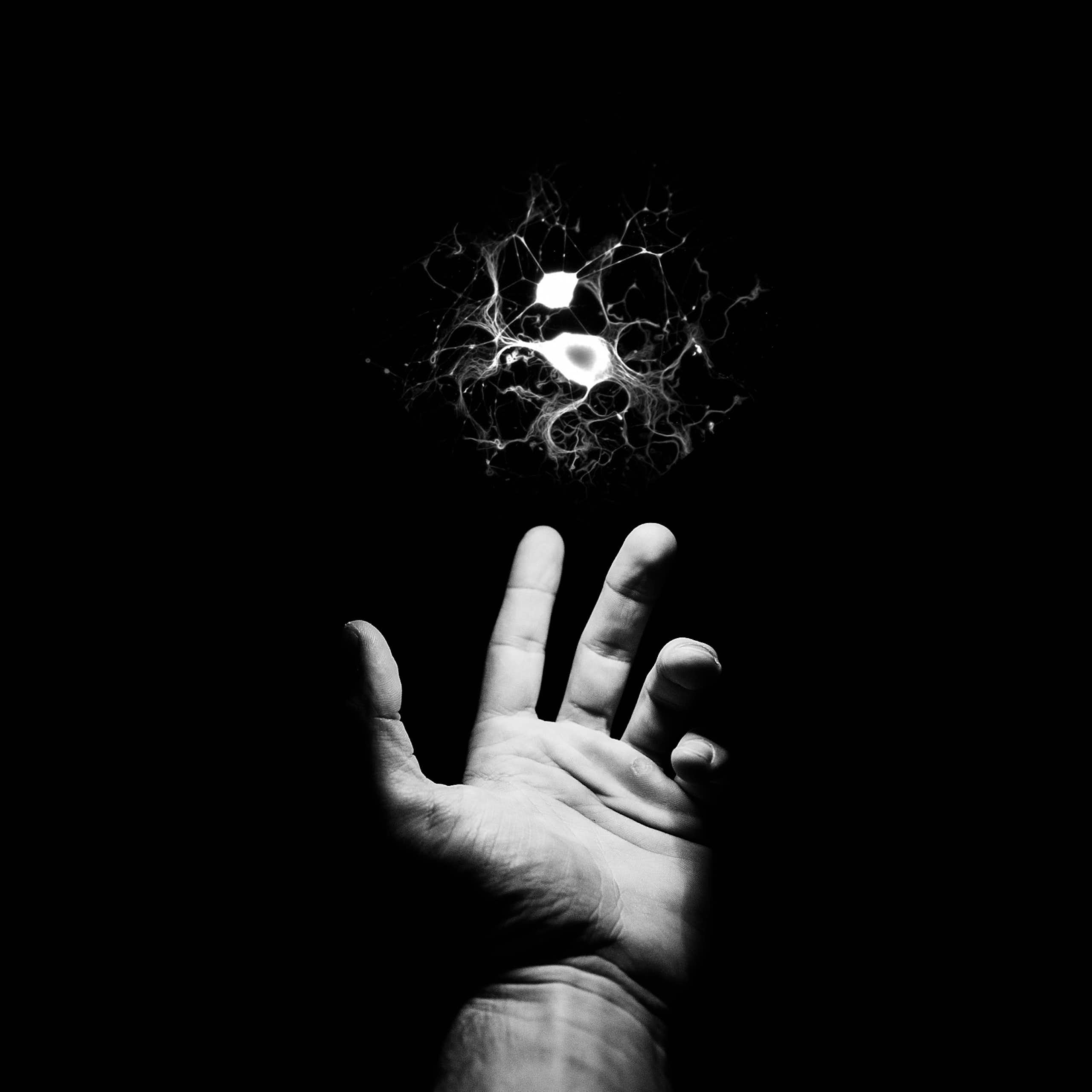 Illustration of outstretched hand reaching for a floating neuron