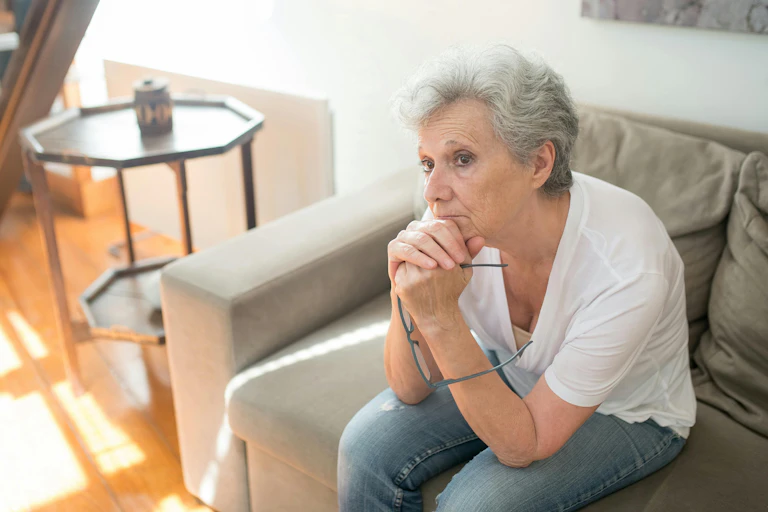 Older woman sits, wondering