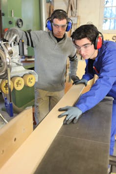 Carpenter and apprentice working in studio