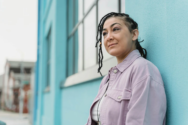 Midlife woman leans against a building