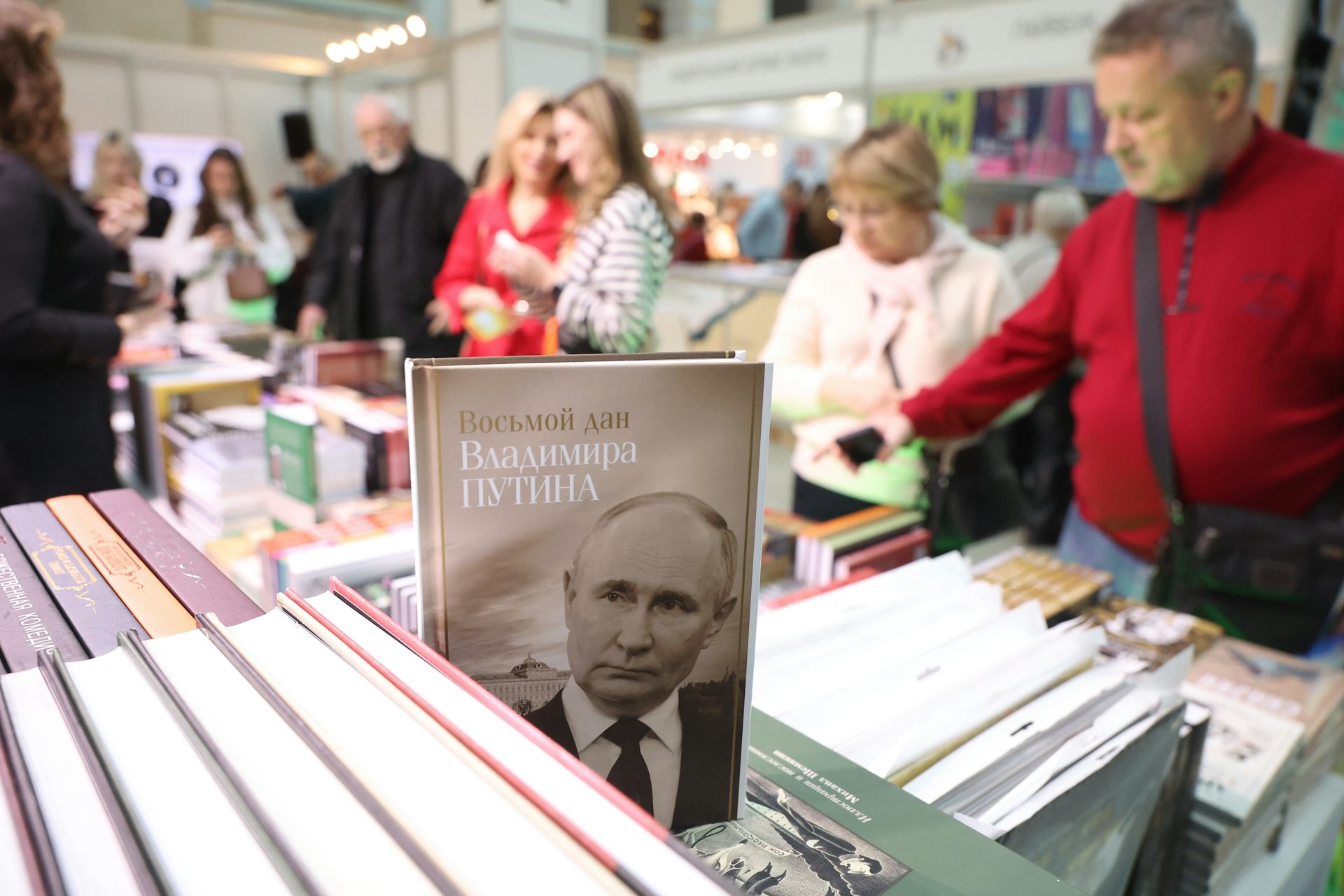 Muscovites browse through books with a book about Vladimir Putin in the foreground.