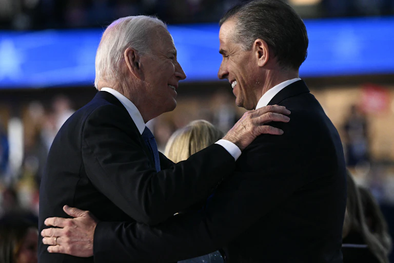 Deux hommes, le président Biden et son fils Hunter, se font une accolade