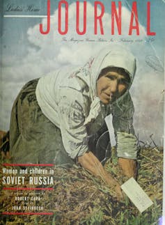 A woman with a cloth over her hair kneels in a field, digging in the dirt with her hands.
