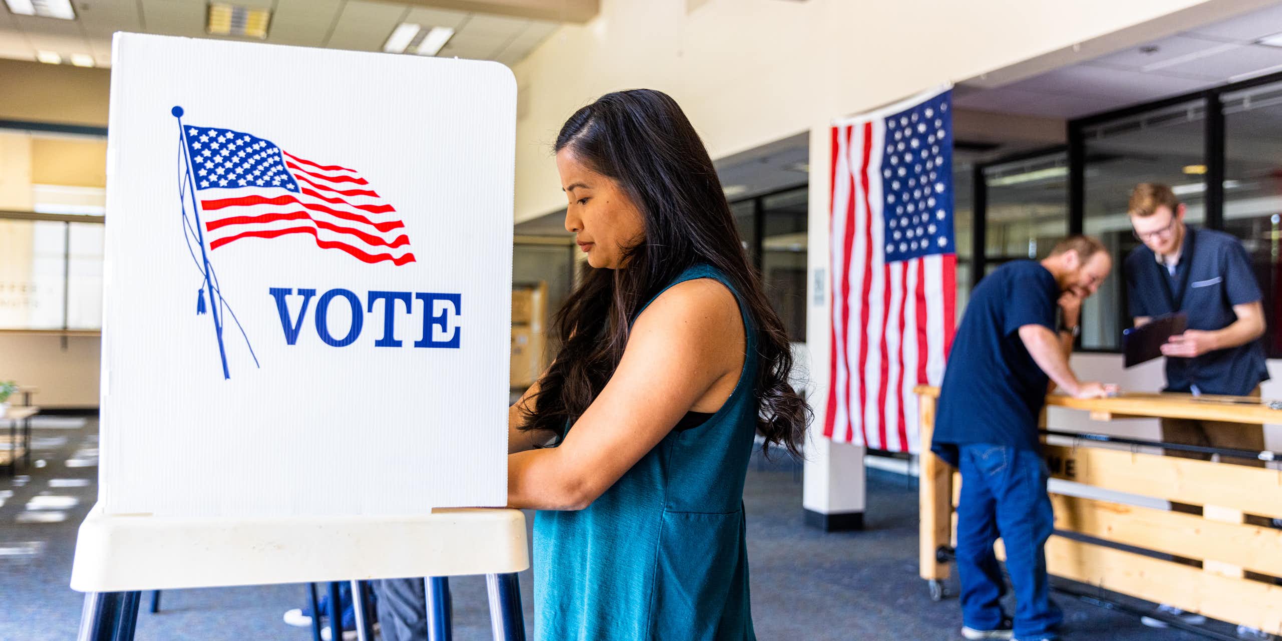 Woman stands at voting booth.