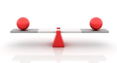 A teeter-totter with balls balanced on each platform