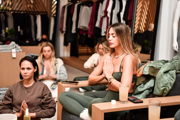 Four women in a meditative pose with their hands folded in a 'namaste.'