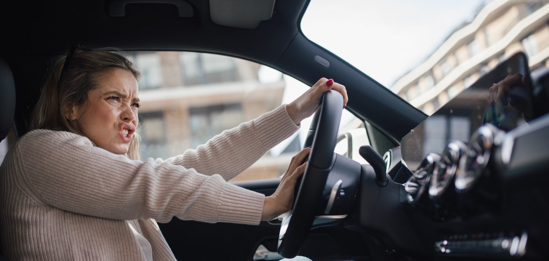 A woman beeps her horn and shouts at another driver in road rage.