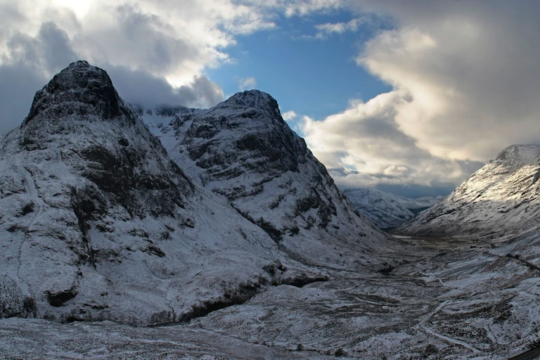 The mountains of Glen Coe looking dramatic in freezing winter weather with a dusting of snow.