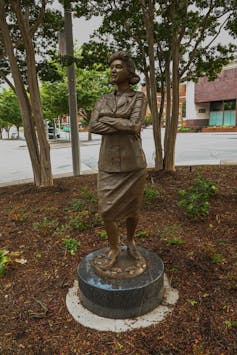 Small bronze statue of a woman in a dress suit