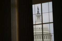 A view of the US Capitol dome through a window.