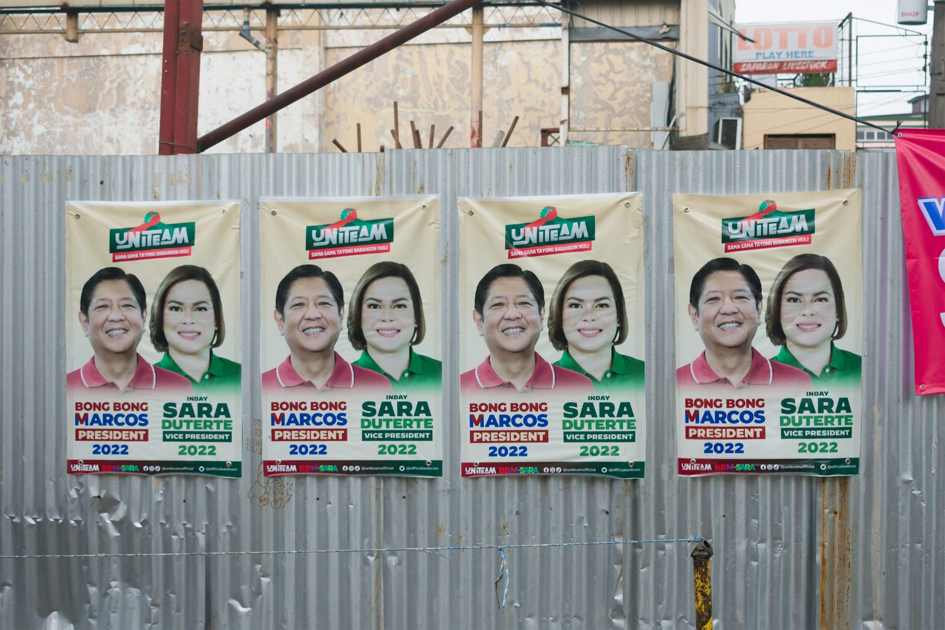 Des affiches de campagne de Ferdinand Marcos Jr. et Sara Duterte sur un mur de tôle