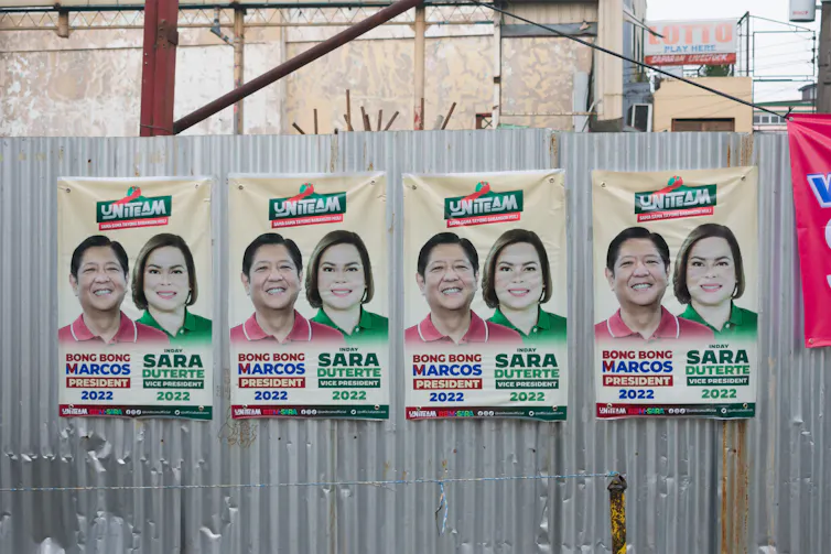 Des affiches de campagne de Ferdinand Marcos Jr. et Sara Duterte sur un mur de tôle