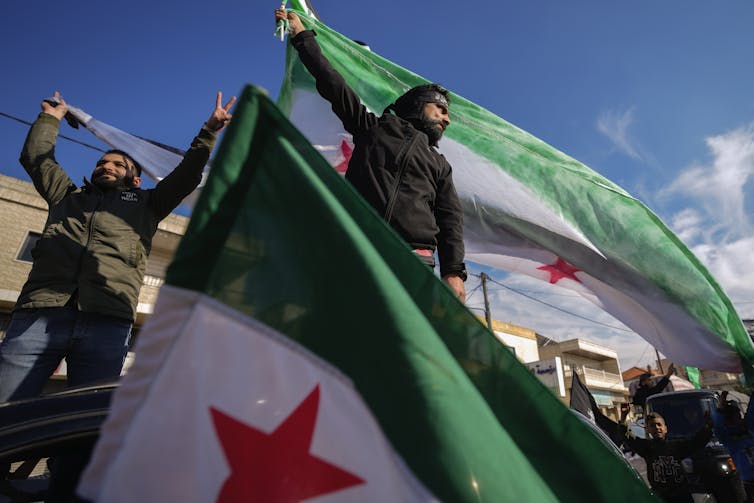 Men hold green white and red flags.