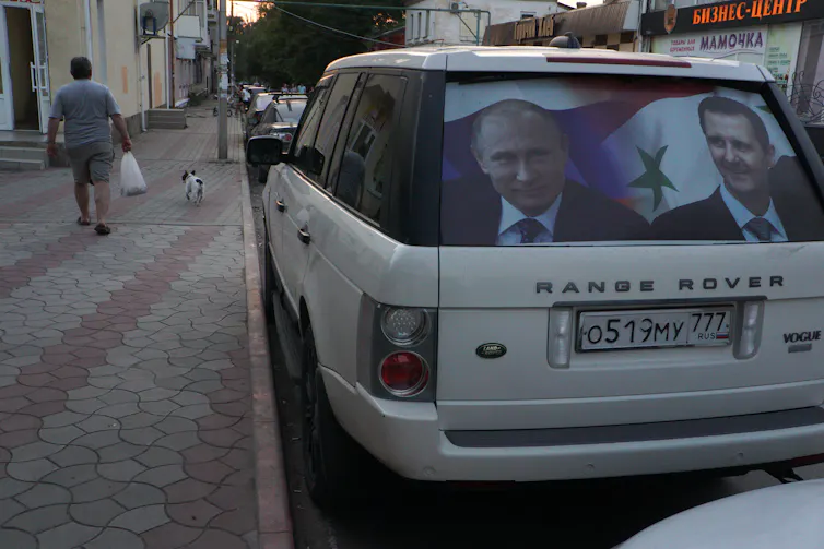 A car has a picture of two men in the rear window.