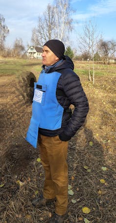A man in a beanie, parka and tan cord pants.