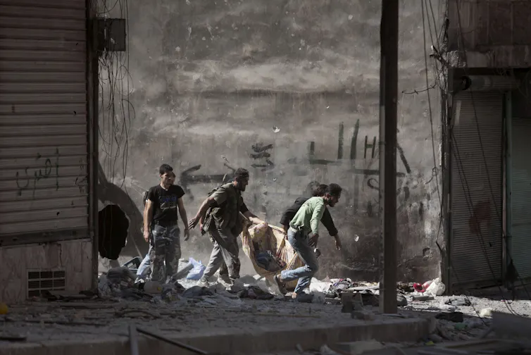 Syrian rebels carrying the body of a fallen comrade.