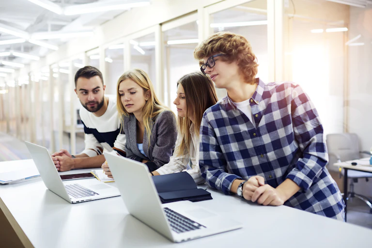 Des étudiants sont en train de travailler devant leurs ordinateurs portables.