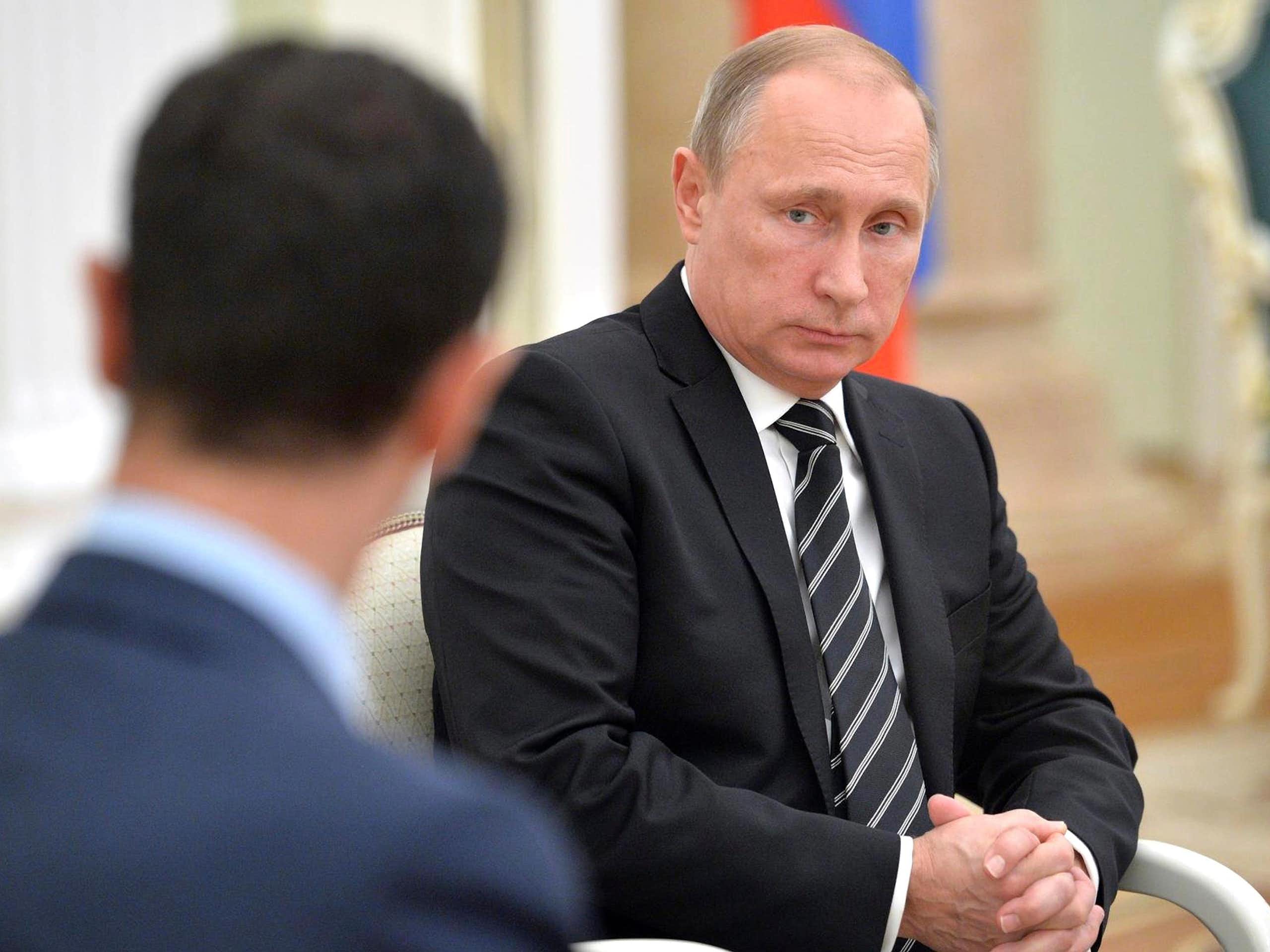 Vladimir Putin looking at Bashar al-Assad.
