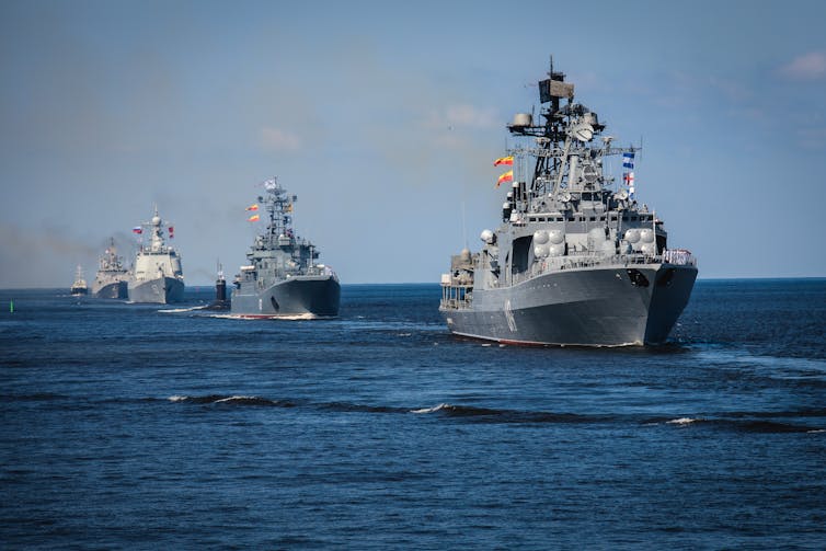 A fleet of Russian warships sailing through the ocean.