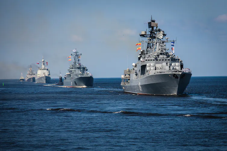A fleet of Russian warships sailing through the ocean.