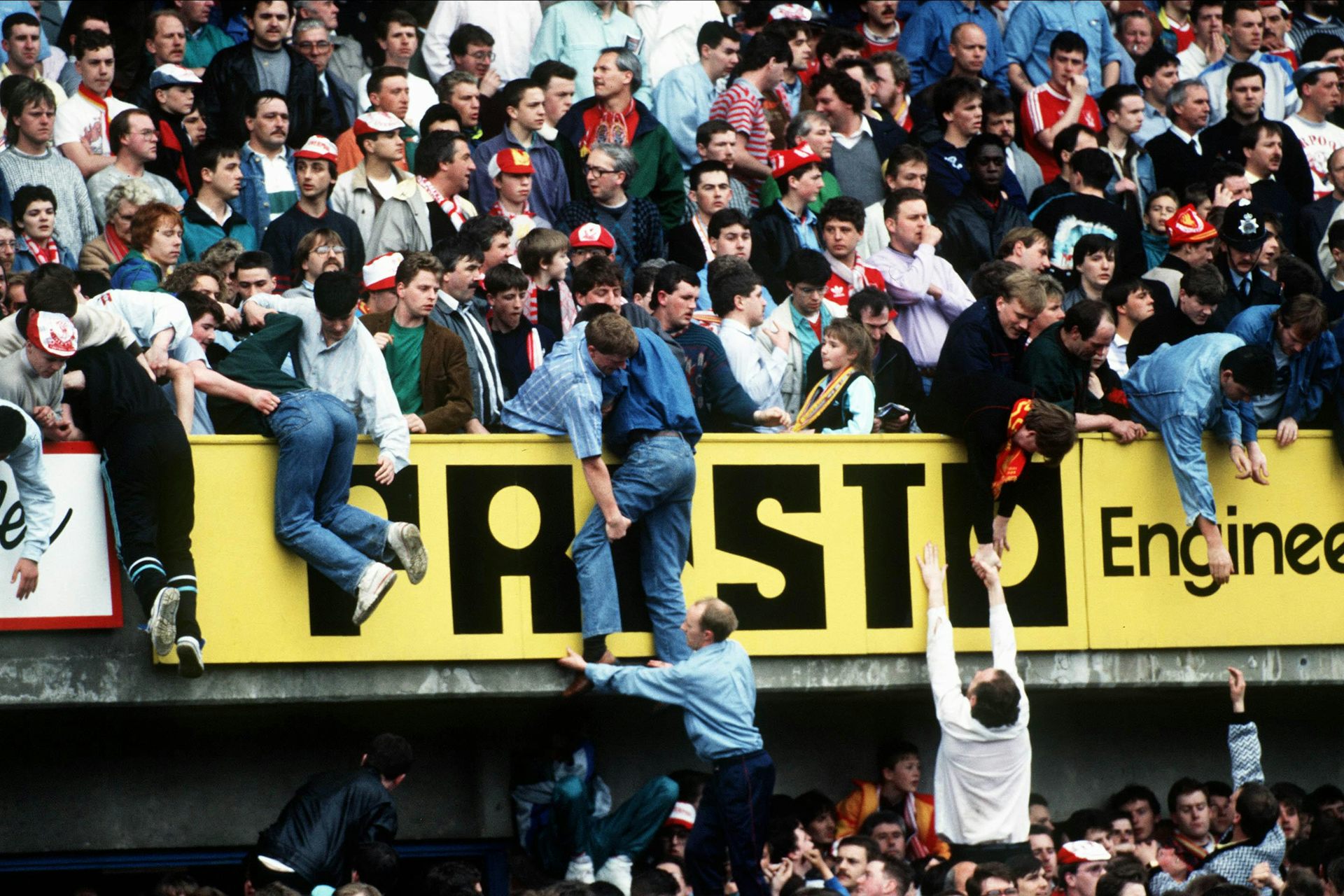 Fans at the Hillsborough stadium helping pull other fans from the crush below.