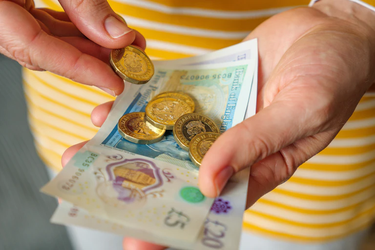 close up of woman's hands as she counts out cash
