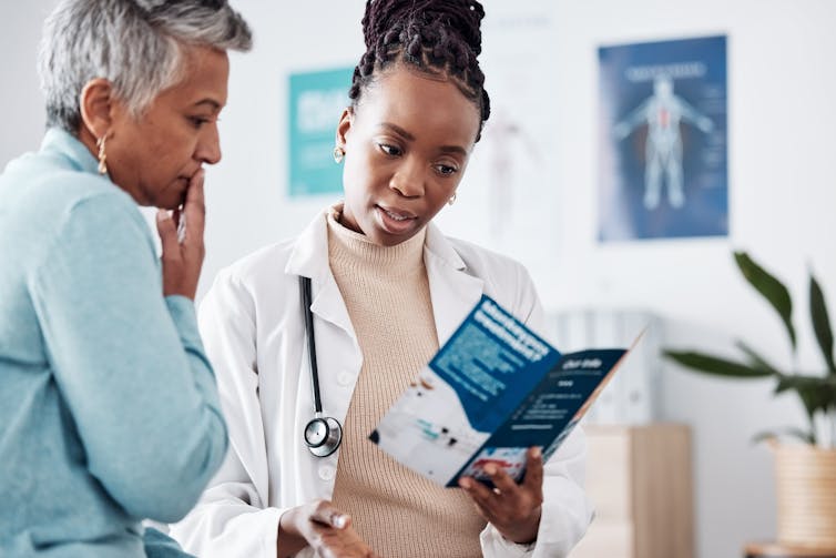 A health-care provider and a patient looking at a brochure