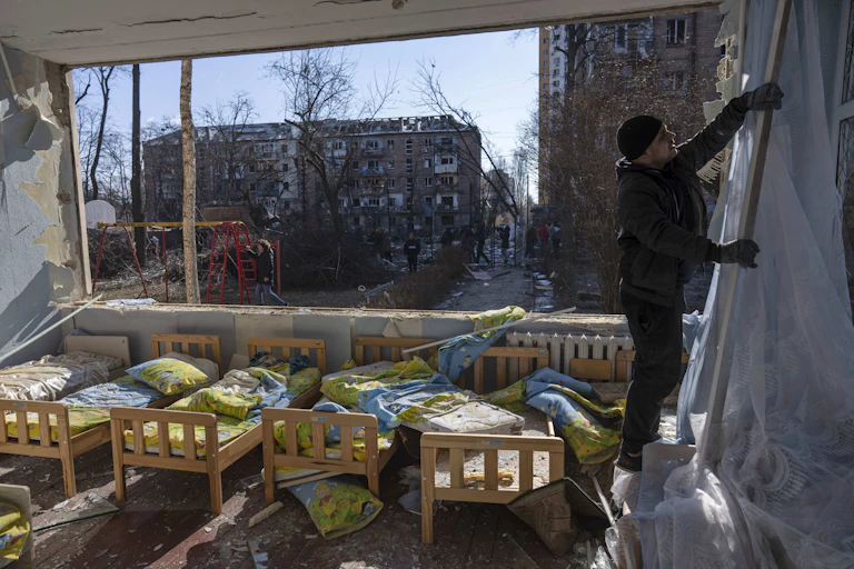 Small beds and a broken window in what appears to be a school