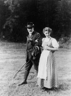 A woman in traditional Austrian dress walks with her bearded father.